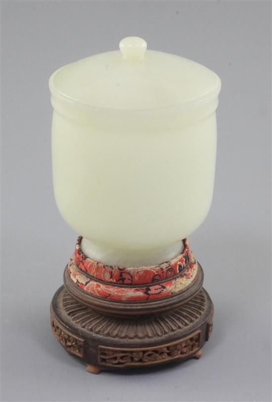 A Chinese pale celadon jade jar and cover, 19th / early 20th century, height 7.8cm, two colour wood stand